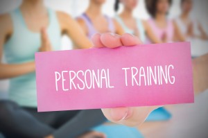 Woman holding pink card saying personal training